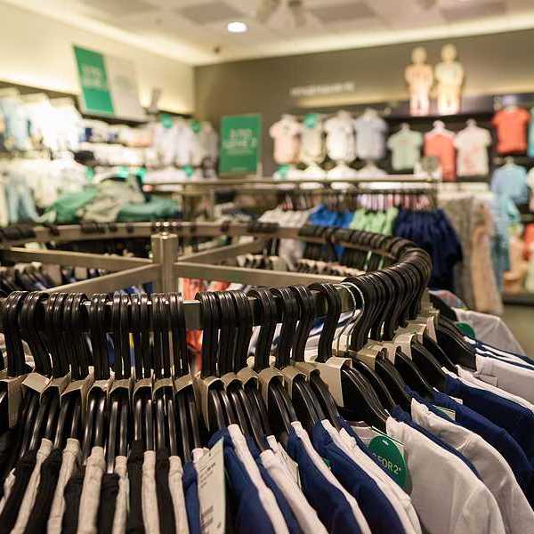 A clothing store with racks of multi-colored clothing