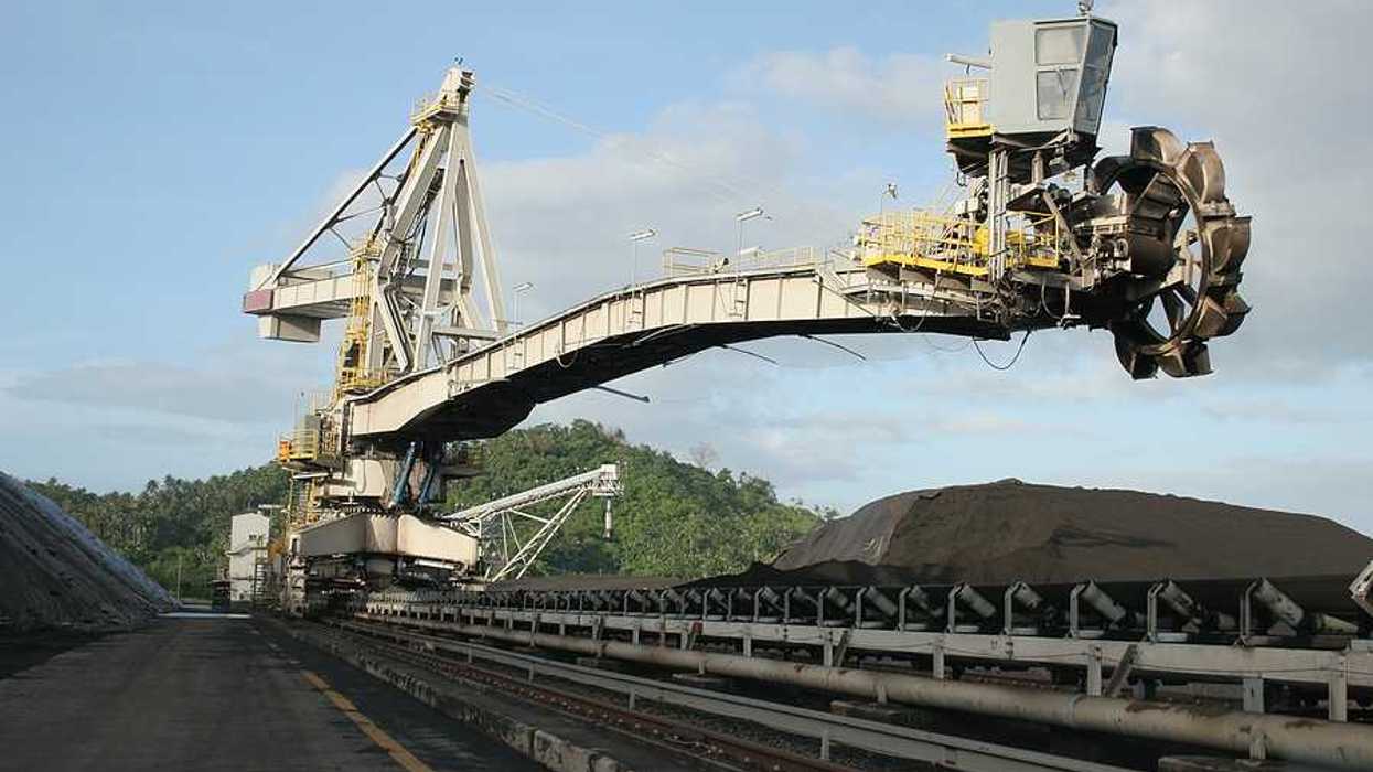 A coal drill hovering over piles of coal