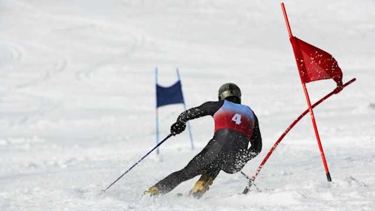 A competitive skiier dodging red flags