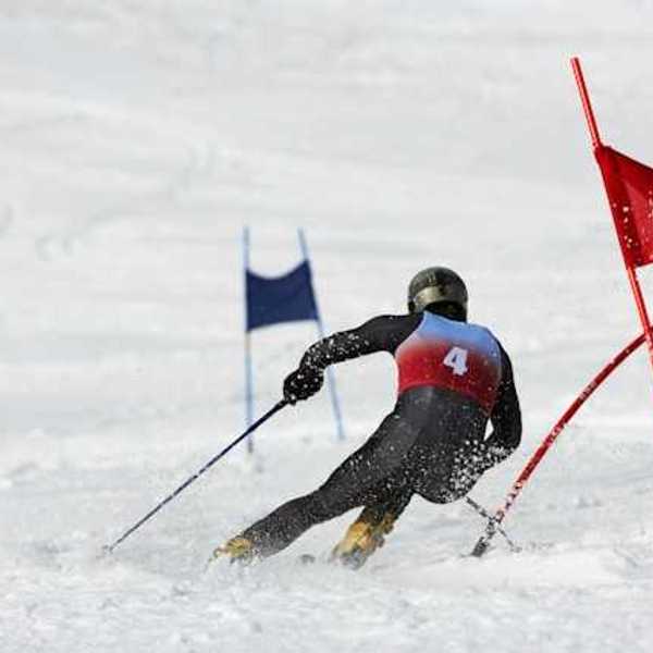 A competitive skiier dodging red flags