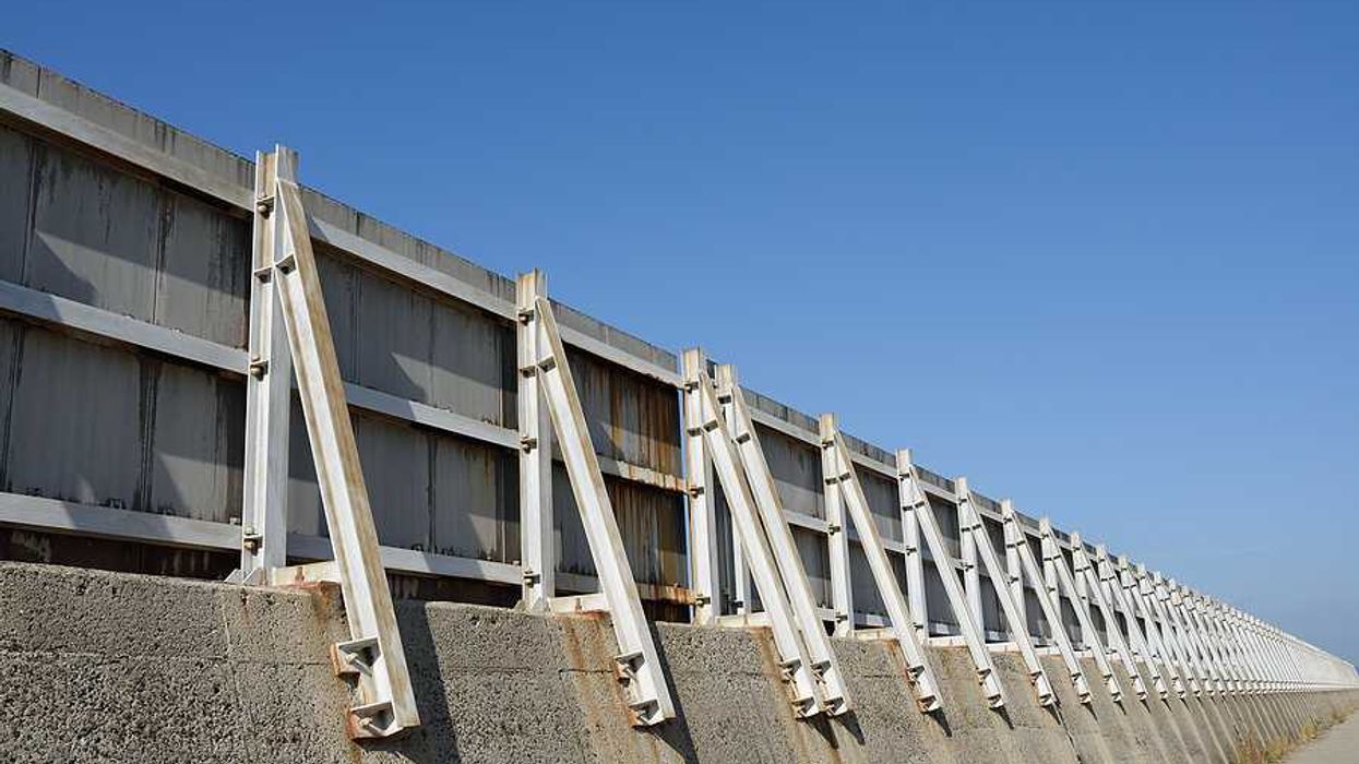 A concrete and metal seawall stretching into the distance