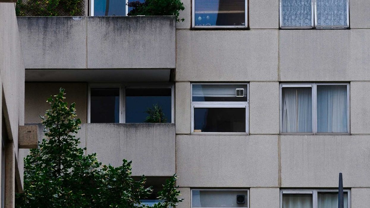 A concrete apartment block with balconies and aluminum windows