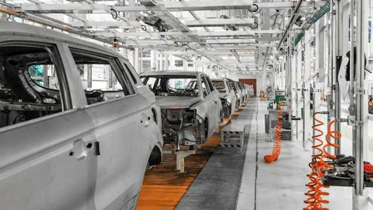 A conveyer belt of electric vehicles being assembled in a factory