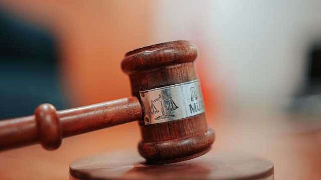A court room gavel sitting on a wooden surface