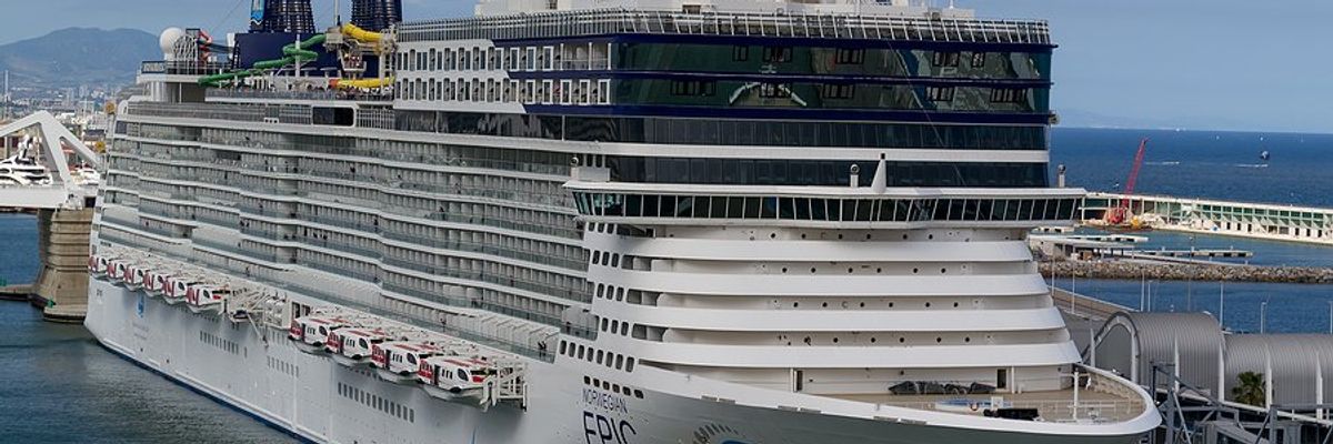 A cruise ship next to a dock in Barcelona Spain.