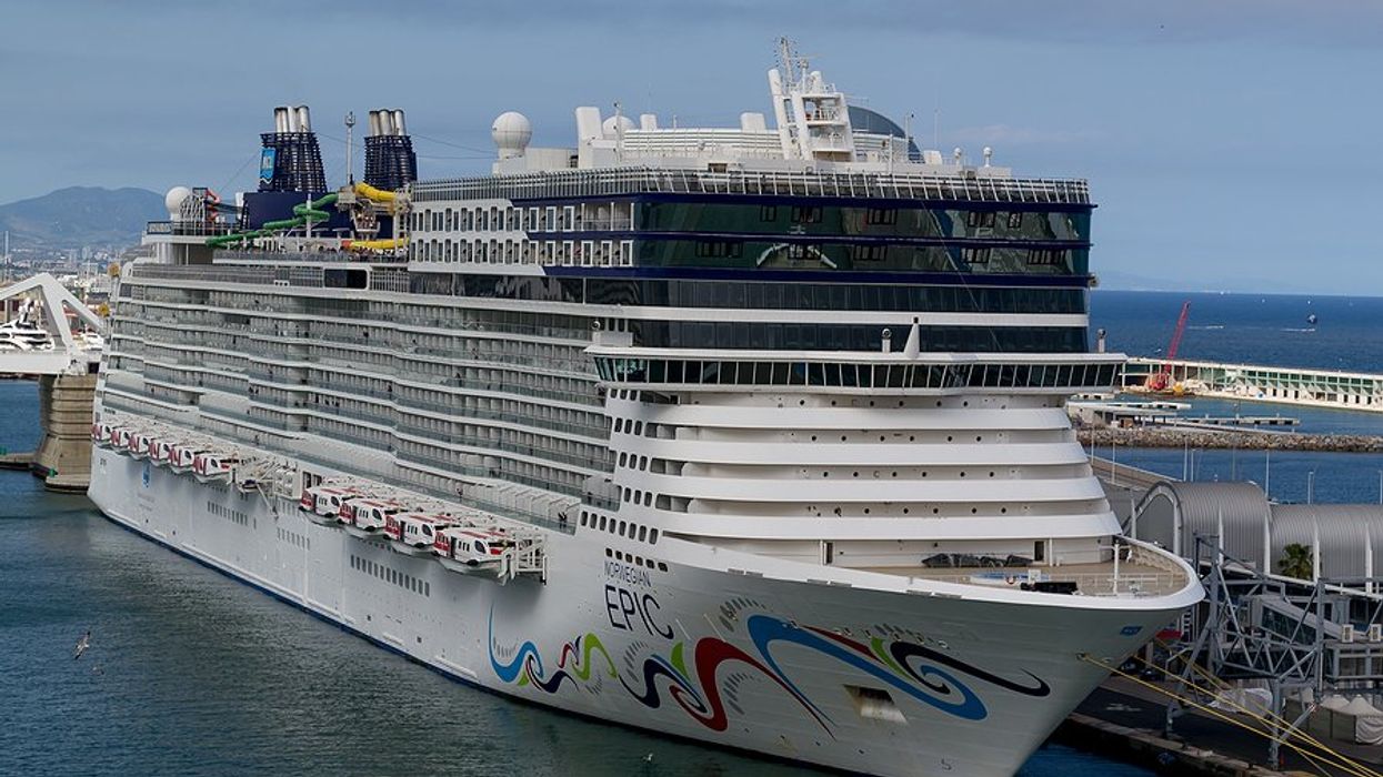 A cruise ship next to a dock in Barcelona Spain.