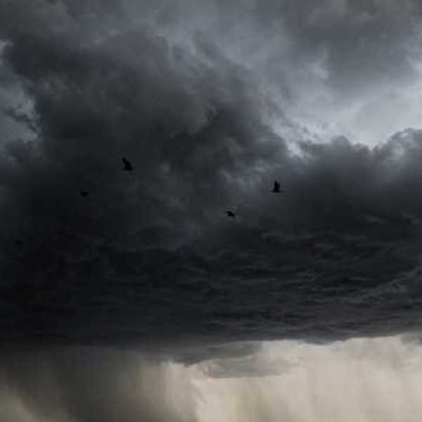 A dark storm cloud with rain in the distance