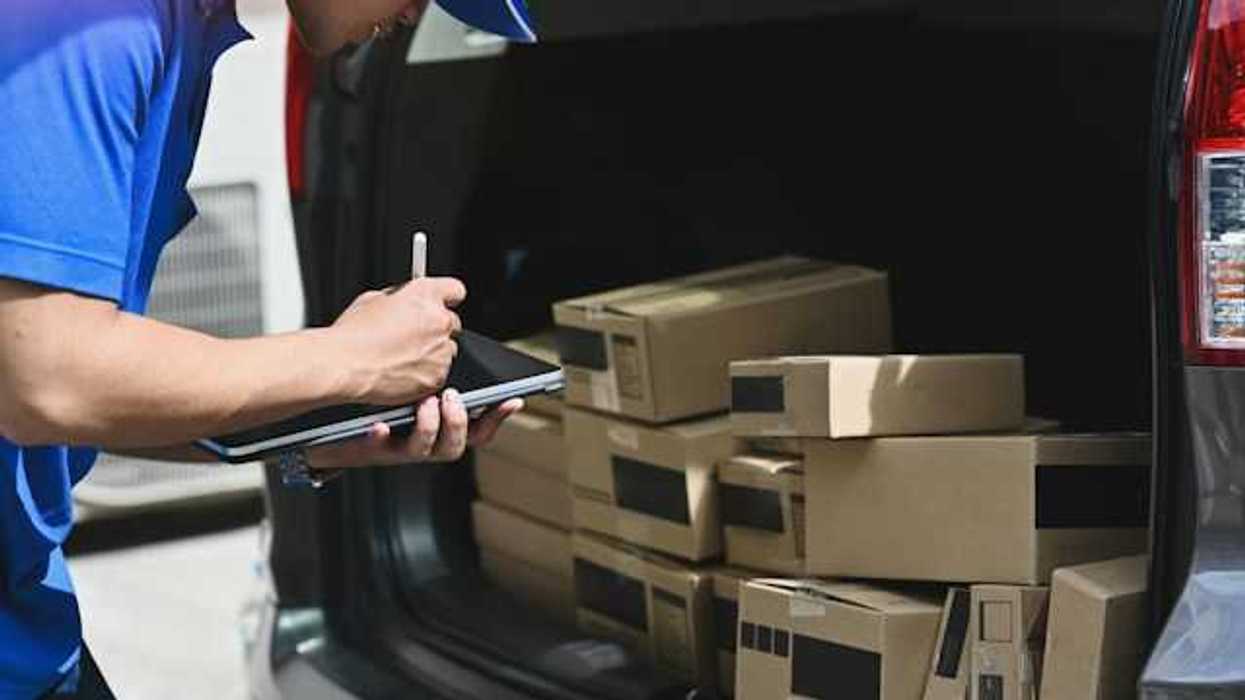 A delivery driver reviewing the packages in his truck