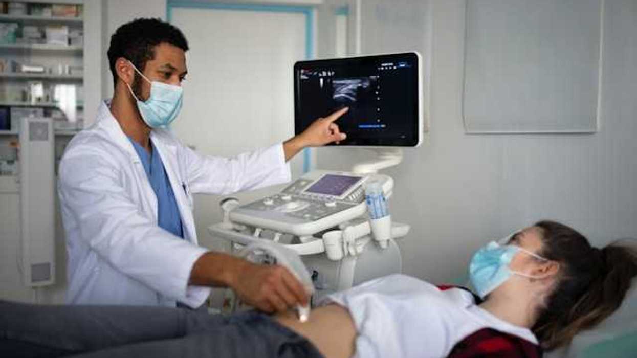 A doctor performing an ultrasound on a pregnant woman