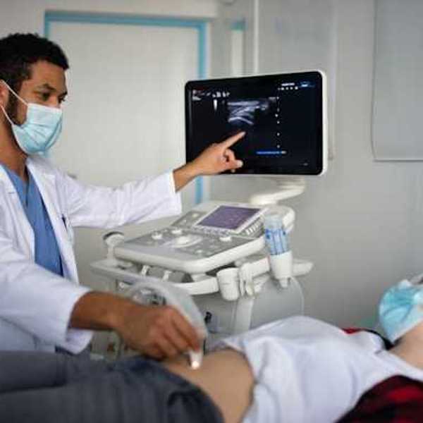 A doctor performing an ultrasound on a pregnant woman