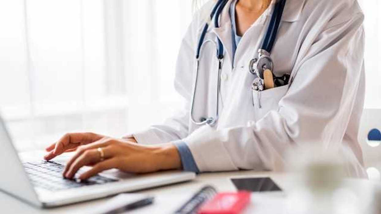 A doctor working on a laptop