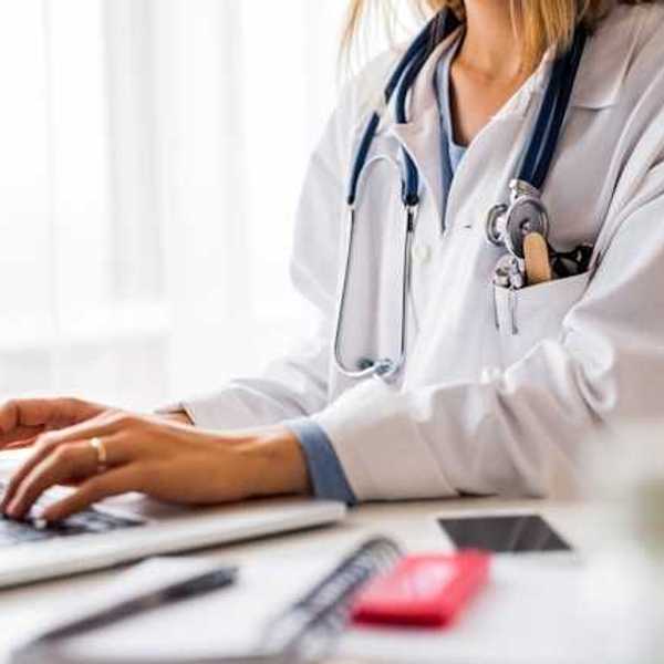A doctor working on a laptop