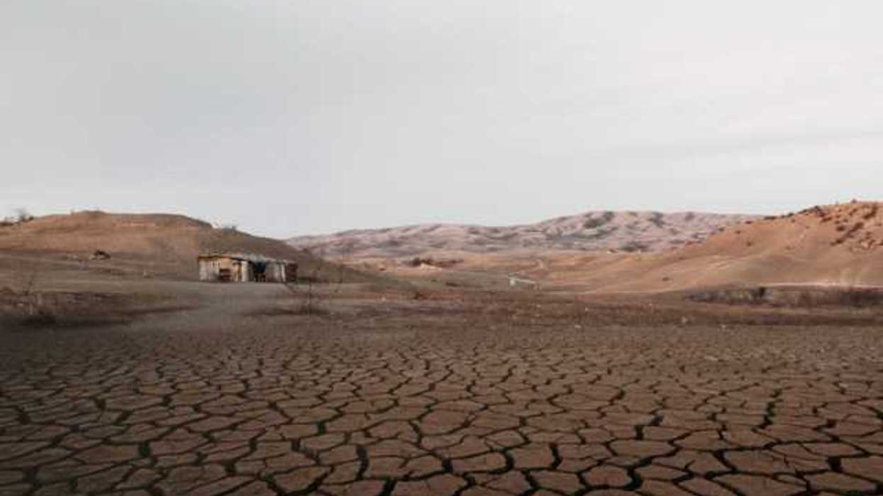 A dried up lakebed with a shack at one end