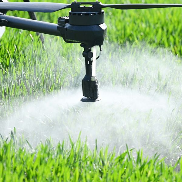 A drone spraying a pesticide on a field.