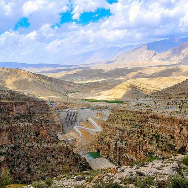 A dry environment with a dam and a small amount of water in view