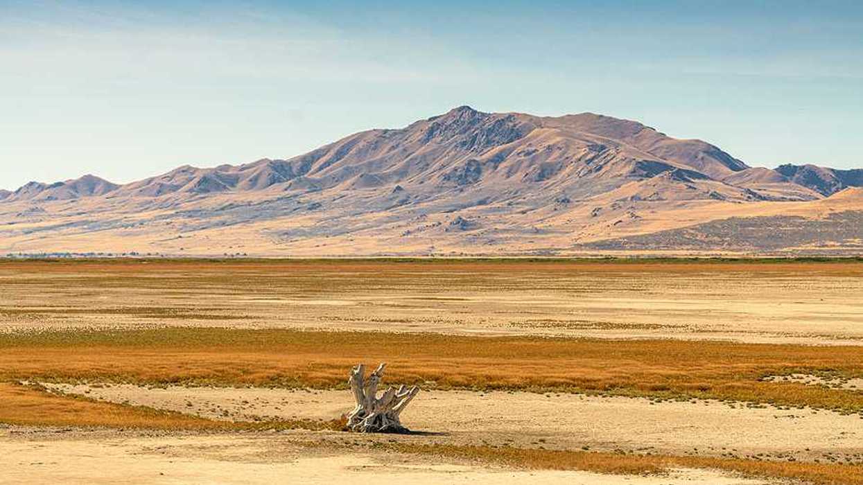 A dry section of the Great Salt Lake with mountains in the background