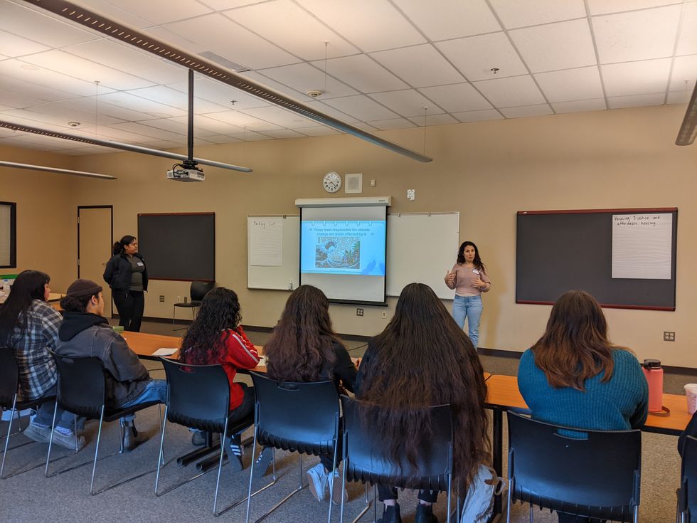 A eoman standing in front of students in a classroom.