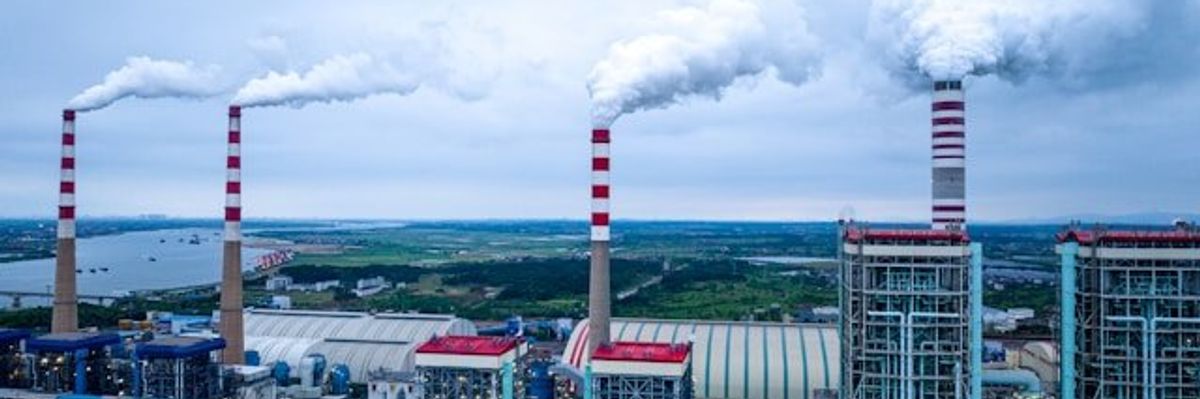 A factory with smoke spewing from smokestacks.