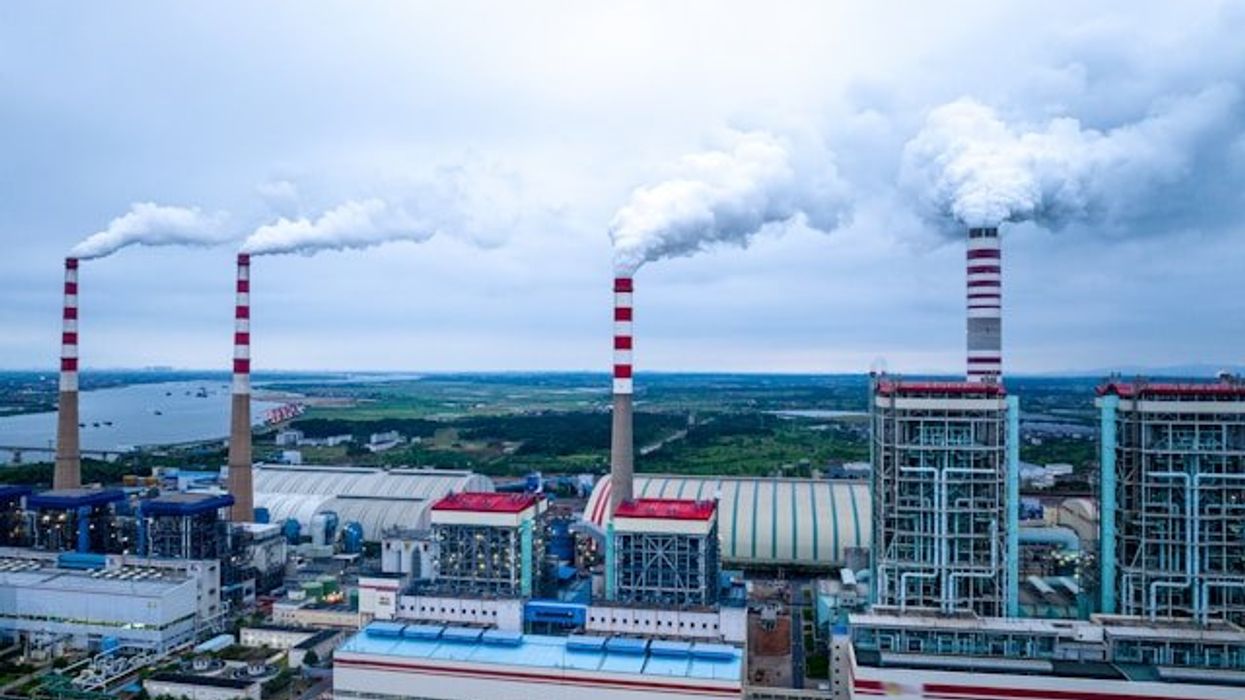 A factory with smoke spewing from smokestacks.