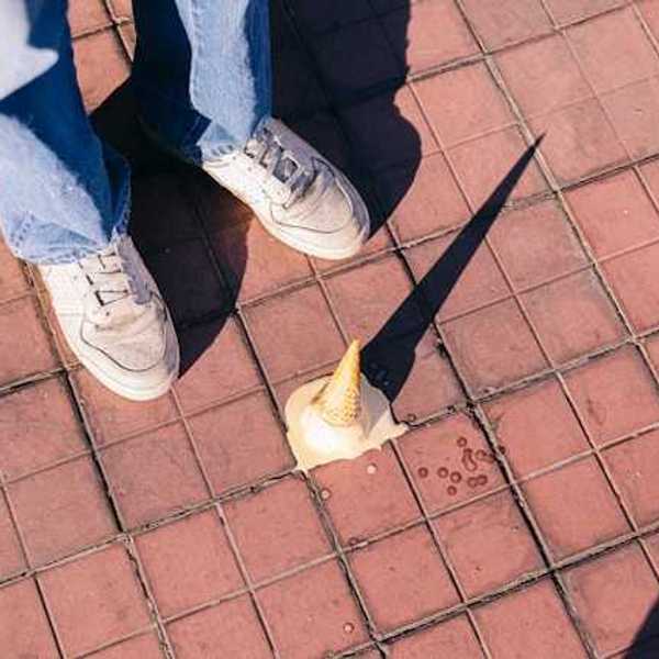 A fallen ice cream cone melting on the sidewalk