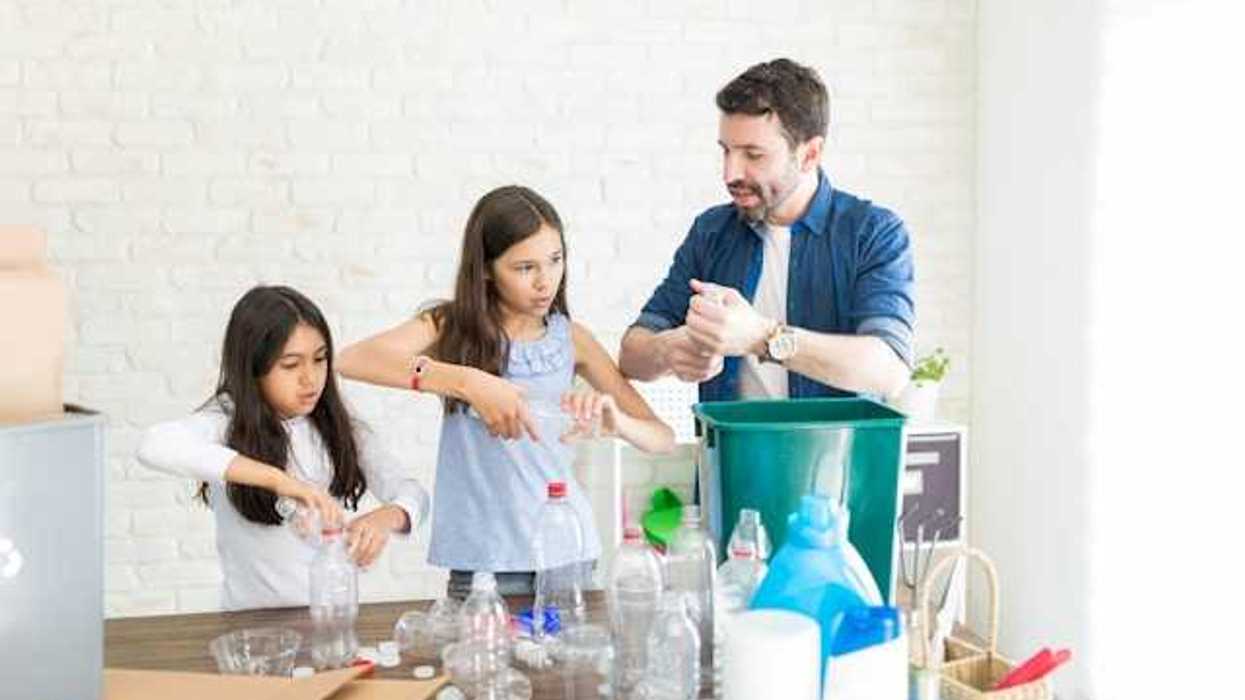 A family placing plastic bottles in recycling cans