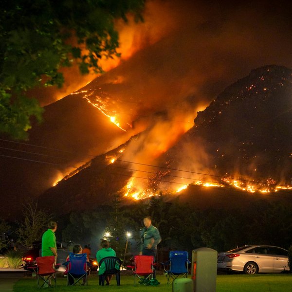 A family watches a nearby wildfire