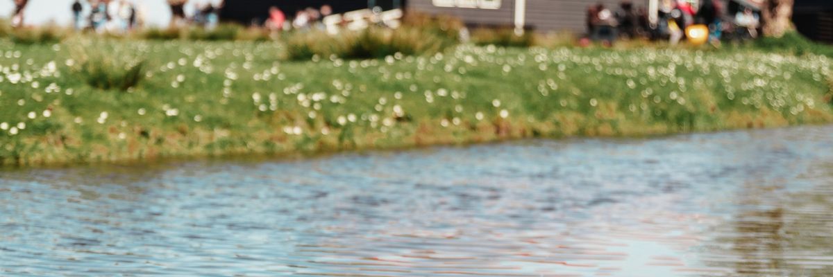 A farm building next to a river.