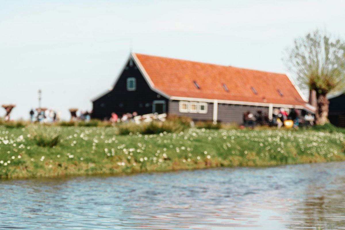 A farm building next to a river.