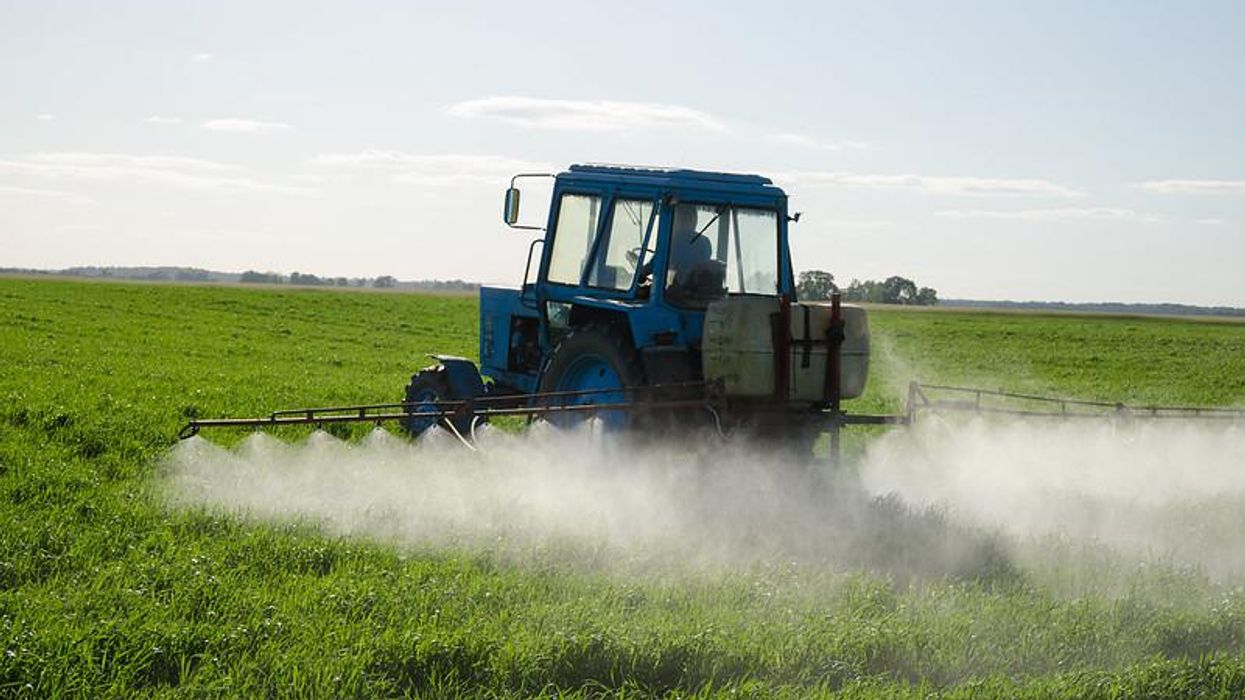 A farmer applies pesticides to their field