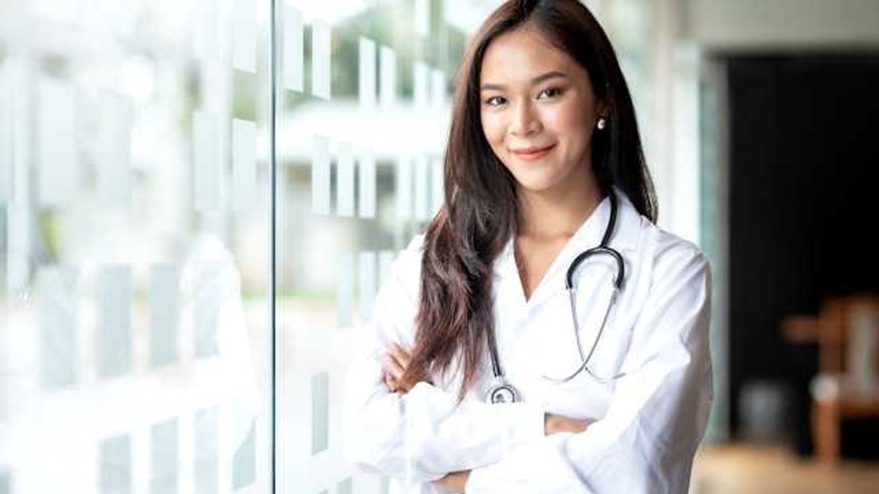 A female doctor standing next to a glass wall