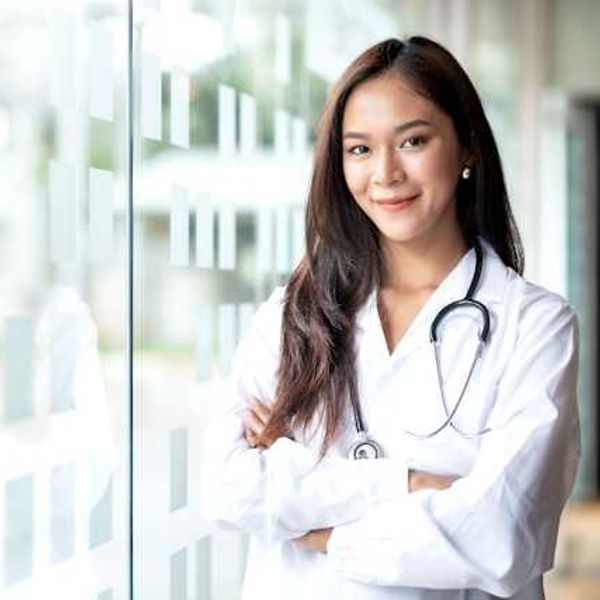 A female doctor standing next to a glass wall