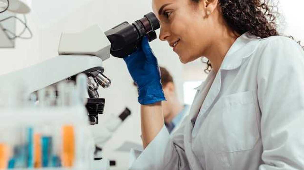 A female scientist looking through a microscope