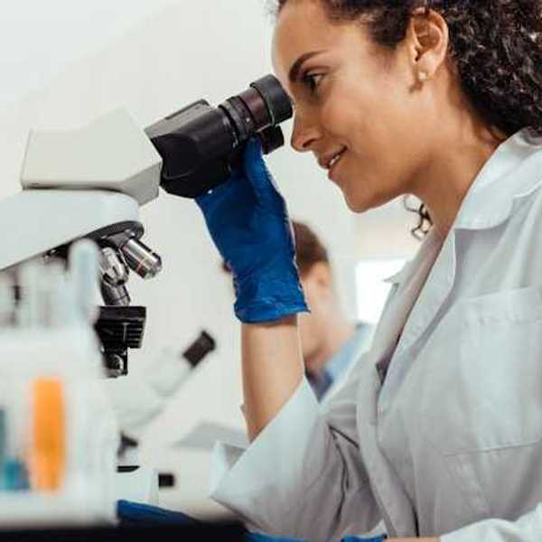 A female scientist looking through a microscope