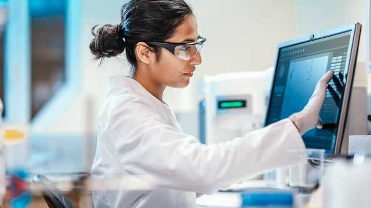 A female scientist sitting in front of a computer screen
