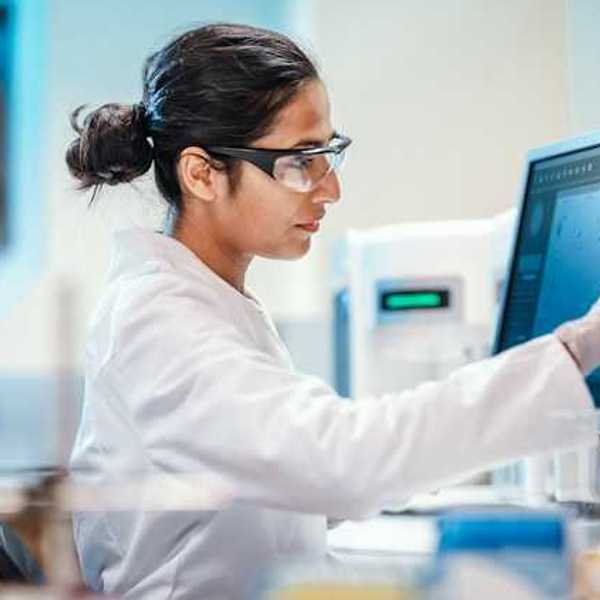 A female scientist sitting in front of a computer screen