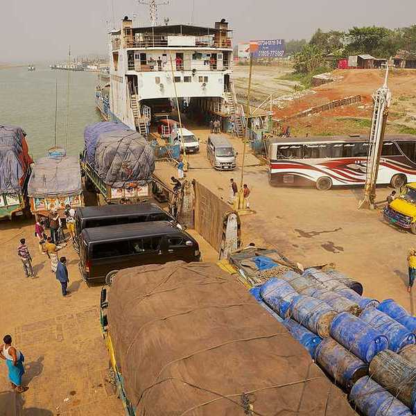 A ferry unloading trucks on the edge of a river in Bangladesh