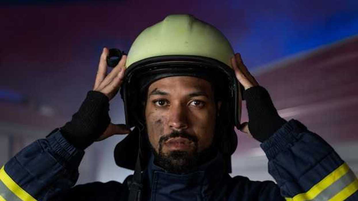 A firefighter putting his helmet on