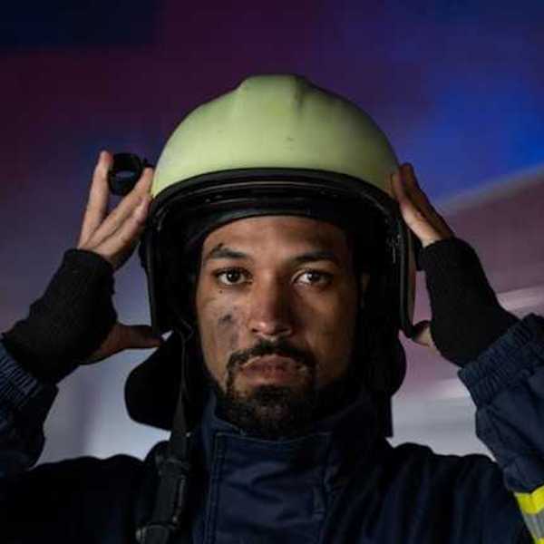 A firefighter putting his helmet on