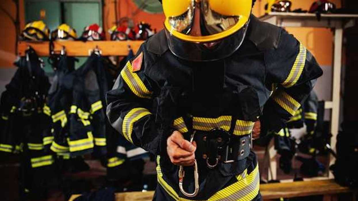 A firefighter putting on his gear