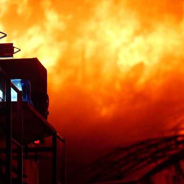 A firetruck pulling up to a house on fire