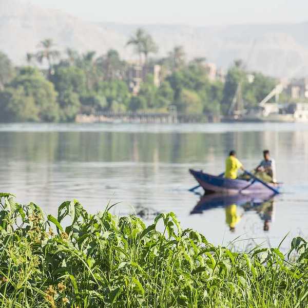 A fishing boat on the Nile River with two fishermen in it