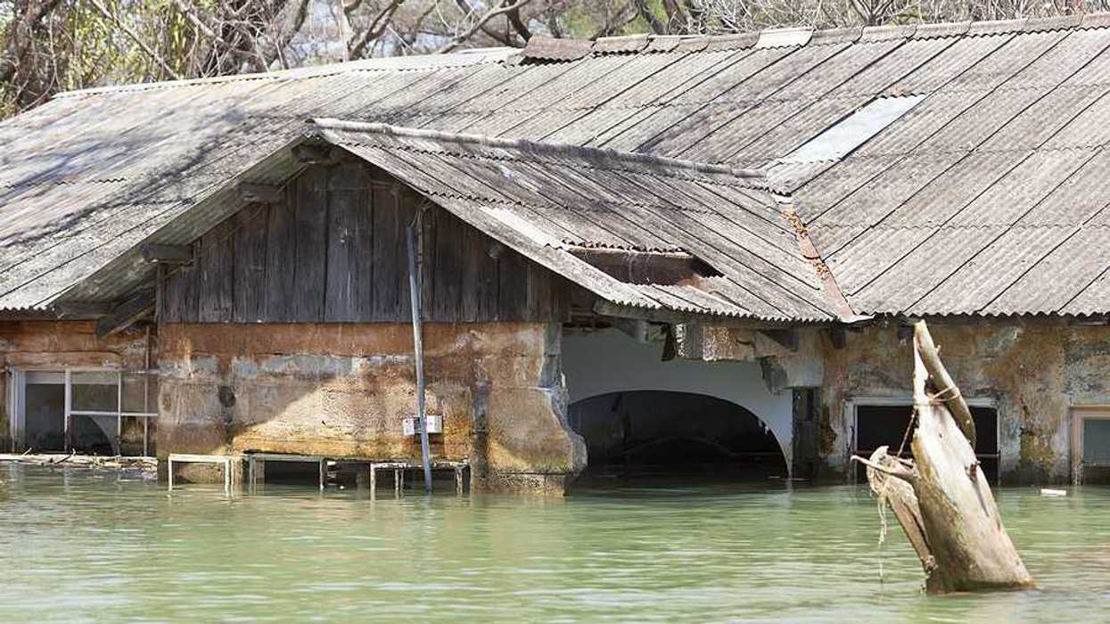 A flooded building with a metal roof