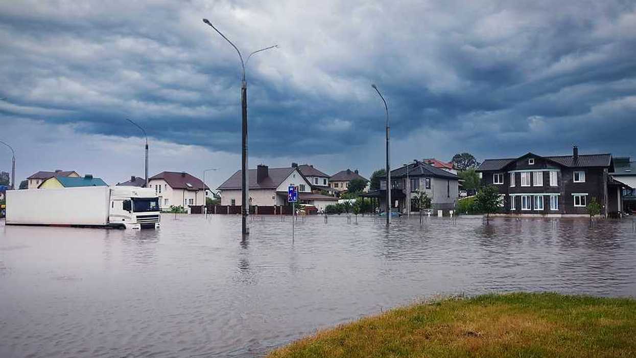 A flooded street with houses in the background