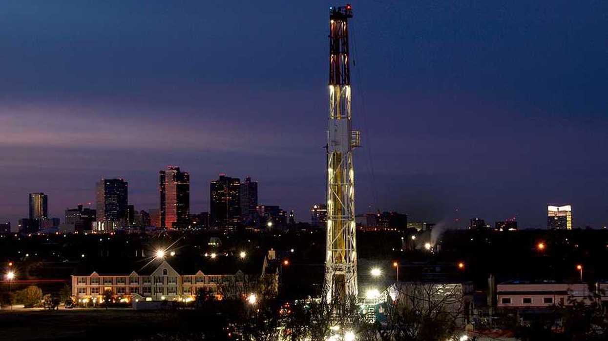 A fracking tower sited in a neighborhood at night