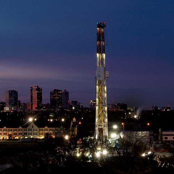 A fracking tower sited in a neighborhood at night
