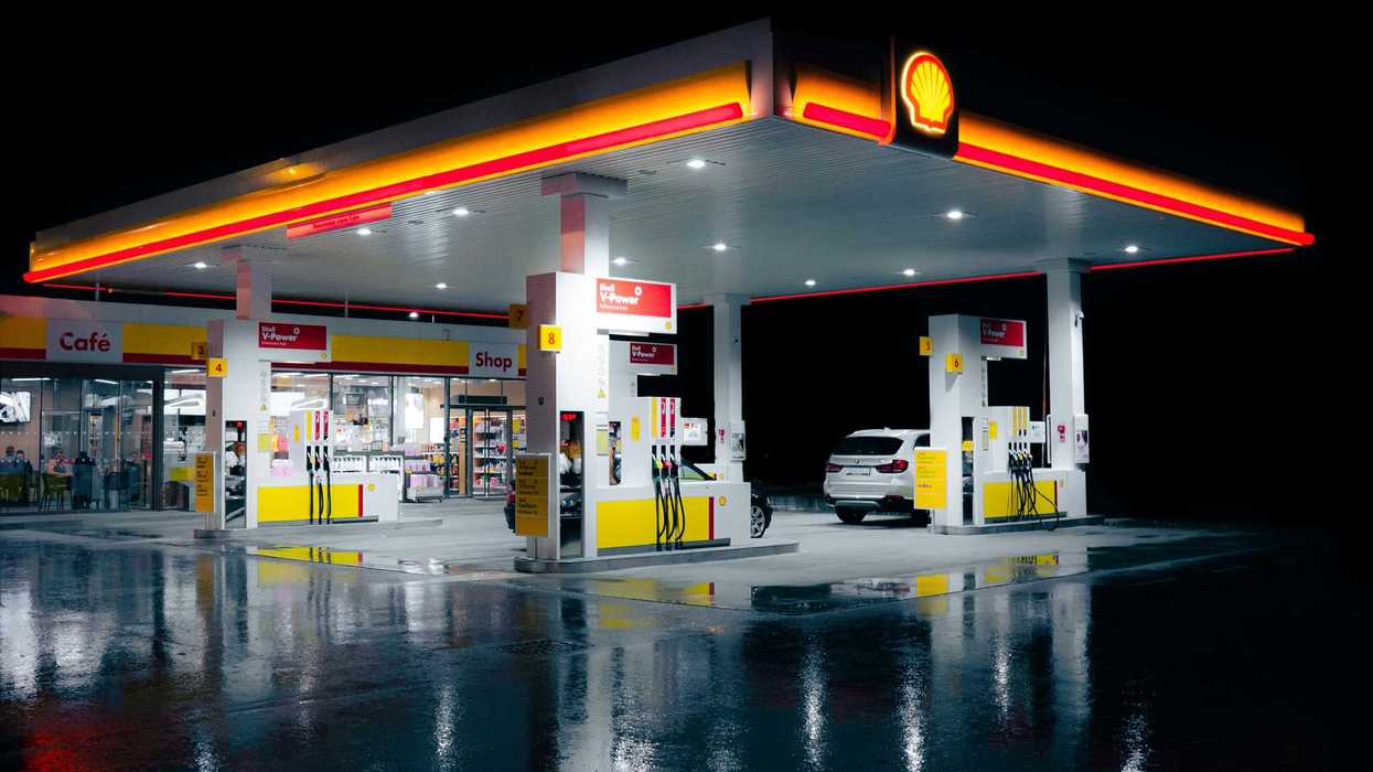 a gas station lit up at night time.