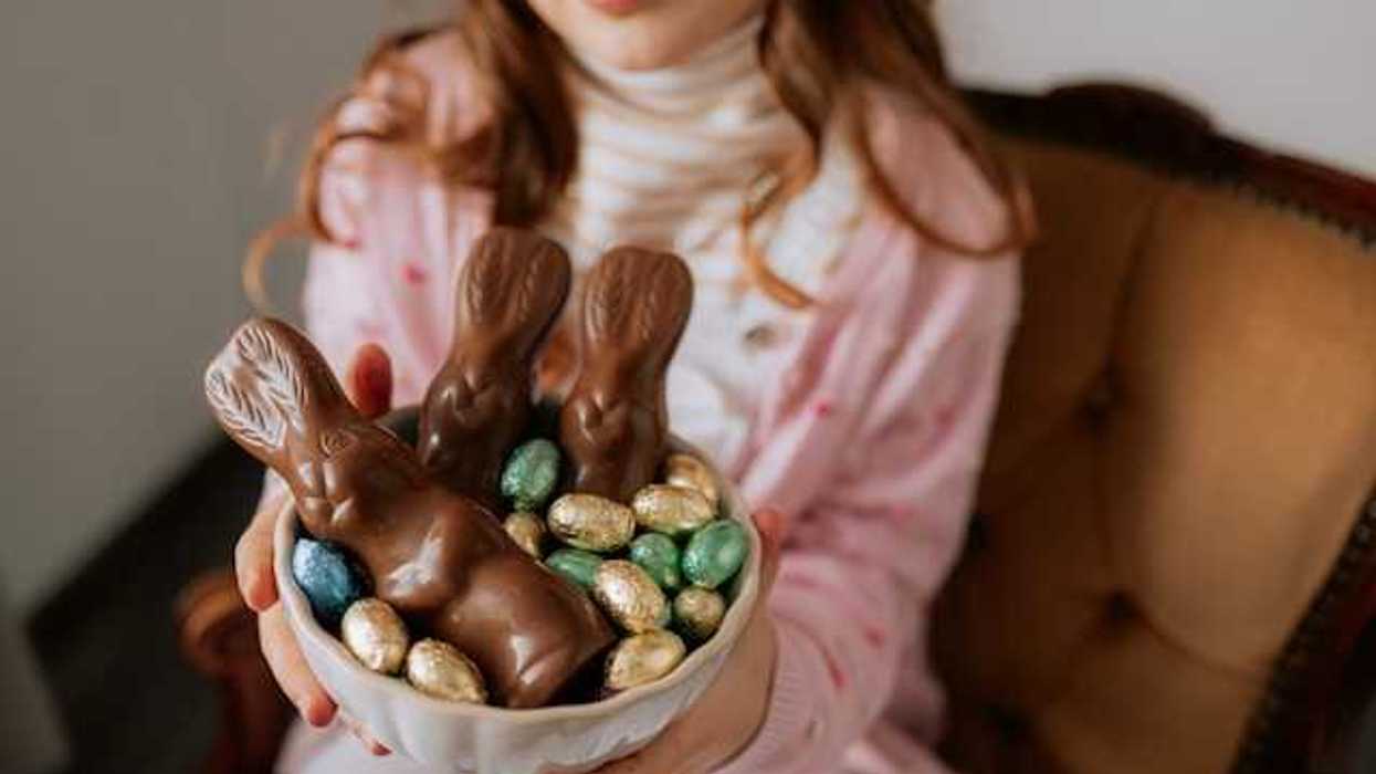 A girl holding a bowl with easter chocolate in it