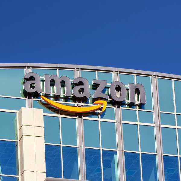 A glass building with the Amazon logo on the side of it