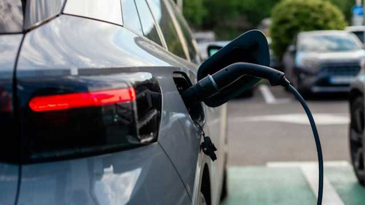 A gray sedan being charged at an electric charging station