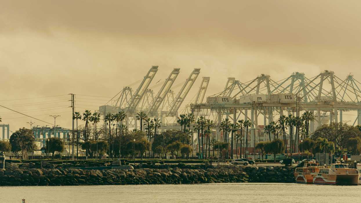 A grayscale photo of the Long Beach port with cranes in the distance